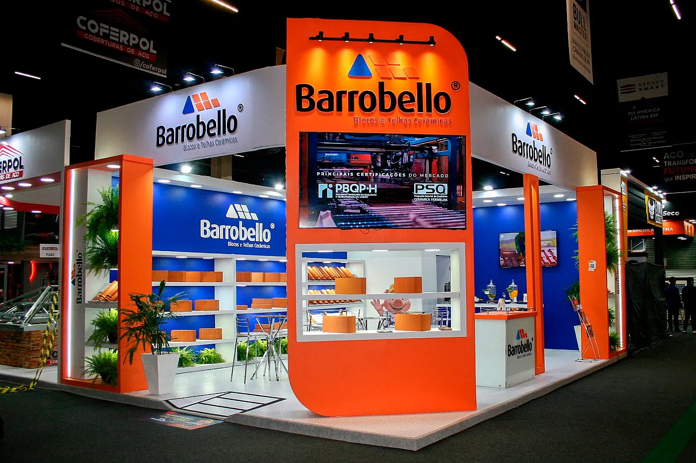 Stand da Barrobello, com fachada curva laranja, painel de mídia e vitrine de blocos e telhas cerâmicas.