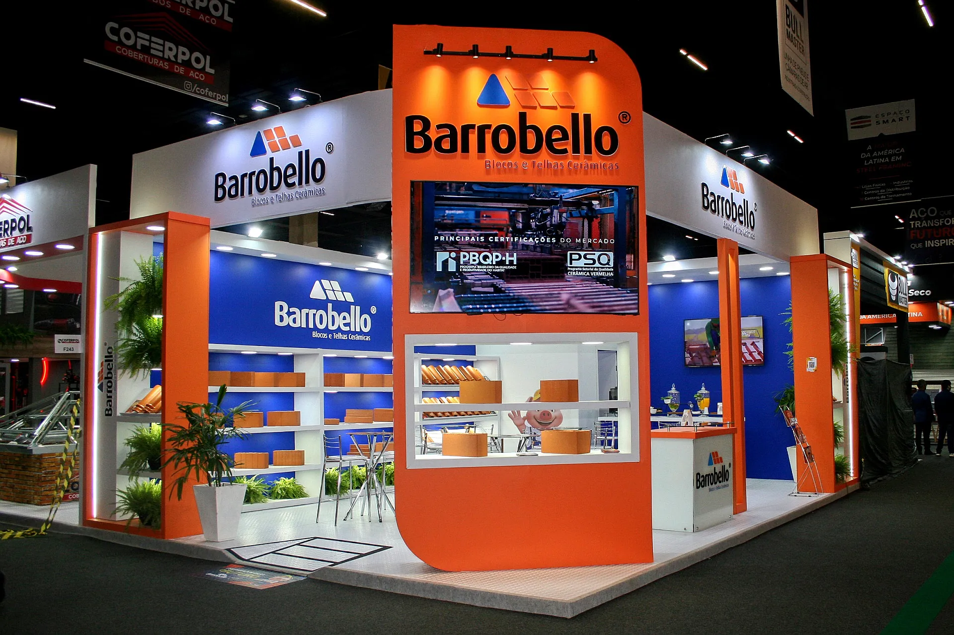 Stand da Barrobello na Feicon 2025, com fachada laranja curva, painel azul de prateleiras e vitrine de blocos e telhas cerâmicas.