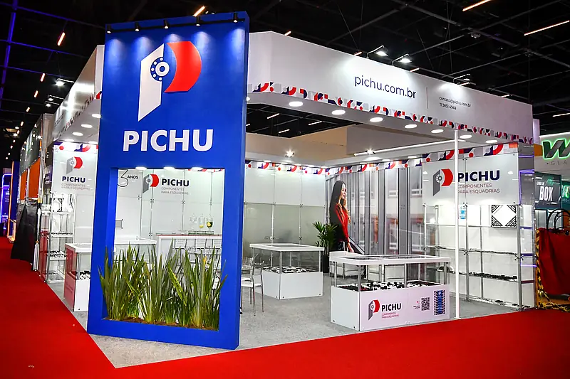 Stand misto azul com totem alto construído, vitrines de vidro modulares e produtos expostos em balcões.